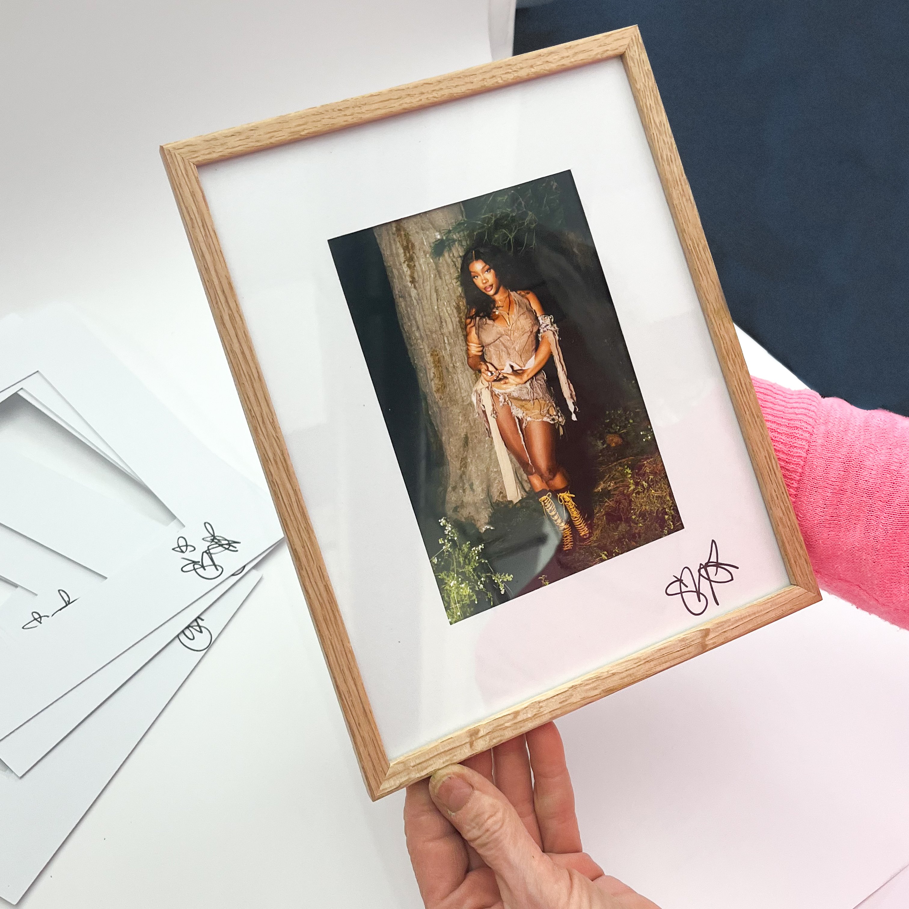 Signed image of SZA in a wooden frame.