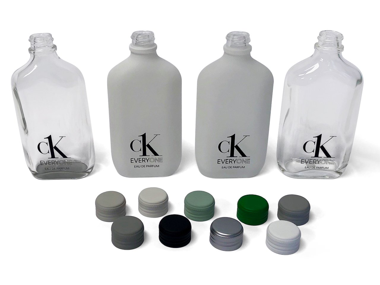 Calvin Klein reusable perfume bottles. Clear and frosted glass with a selection of green and grey bottle caps.